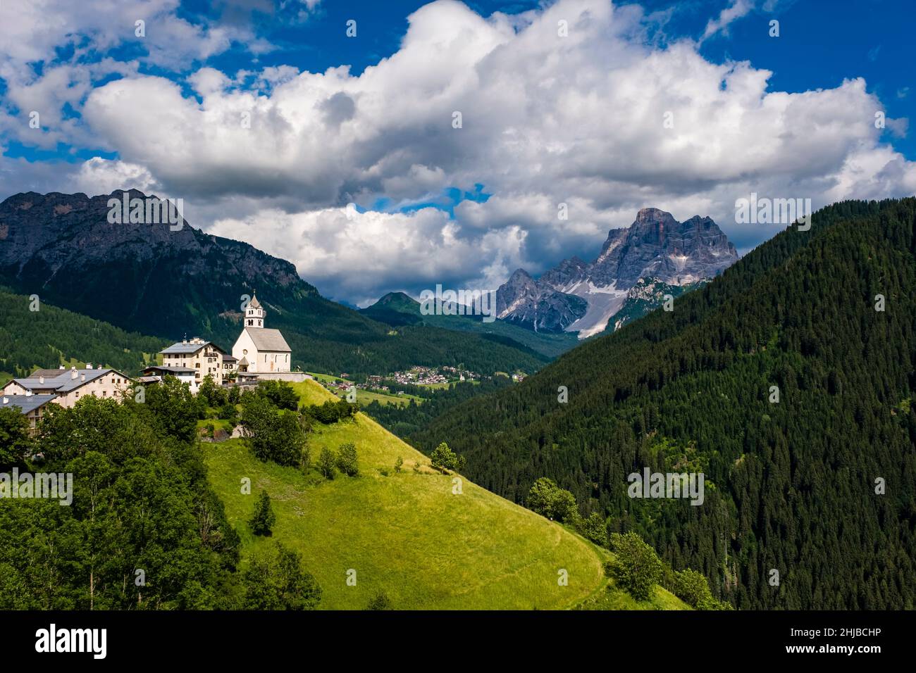 Die Kirche Chiesa Santa Lucia in Colle Santa Lucia am Fuße des Giau-Passes, Passo di Giau, der Gipfel des Monte Pelmo in der Ferne. Stockfoto