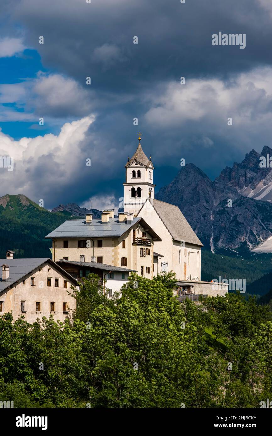 Die Kirche Chiesa Santa Lucia in Colle Santa Lucia am Fuße des Giau-Passes, Passo di Giau, der Gipfel des Monte Pelmo in der Ferne. Stockfoto