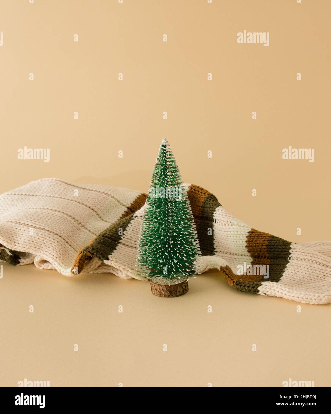 Festliche Idee Schal und Baum einen beigen Hintergrund. Minimalkonzept Weihnachten. Stockfoto