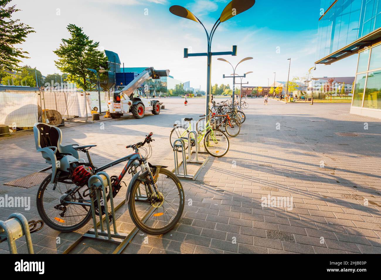 Geparkte Fahrräder auf dem Bürgersteig in der Nähe des Sanoma-Hauses in HELSINKI, FINNLAND Stockfoto