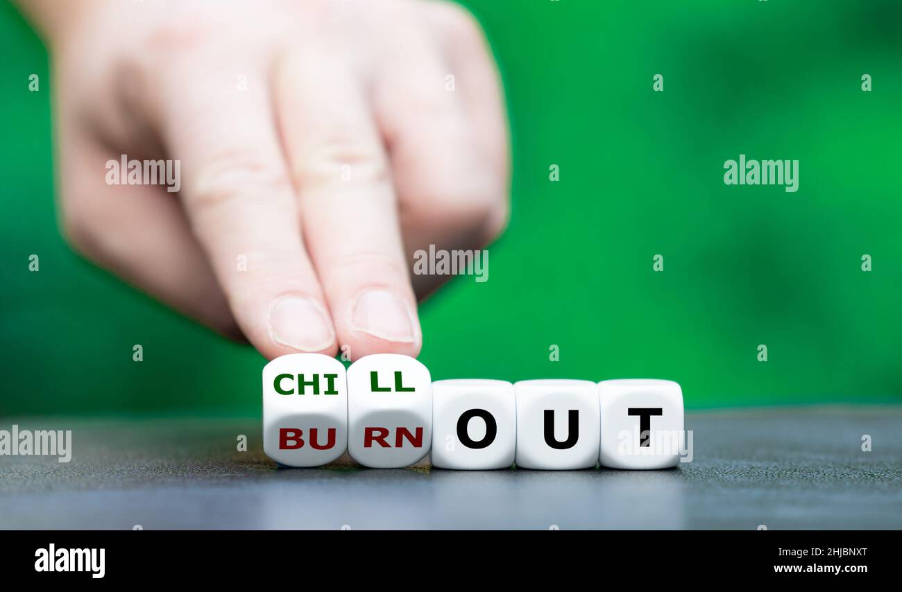 Die Hand dreht Würfel und ändert den Ausdruck „Burn out“ in „Chill out“. Stockfoto