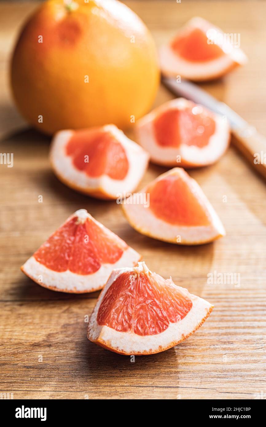 In Scheiben geschnittene Zitrusfrüchte. Gehackte frische Grapefruit auf einem Holztisch. Stockfoto