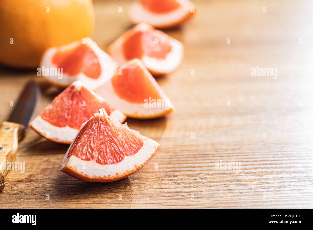 In Scheiben geschnittene Zitrusfrüchte. Gehackte frische Grapefruit auf einem Holztisch. Stockfoto