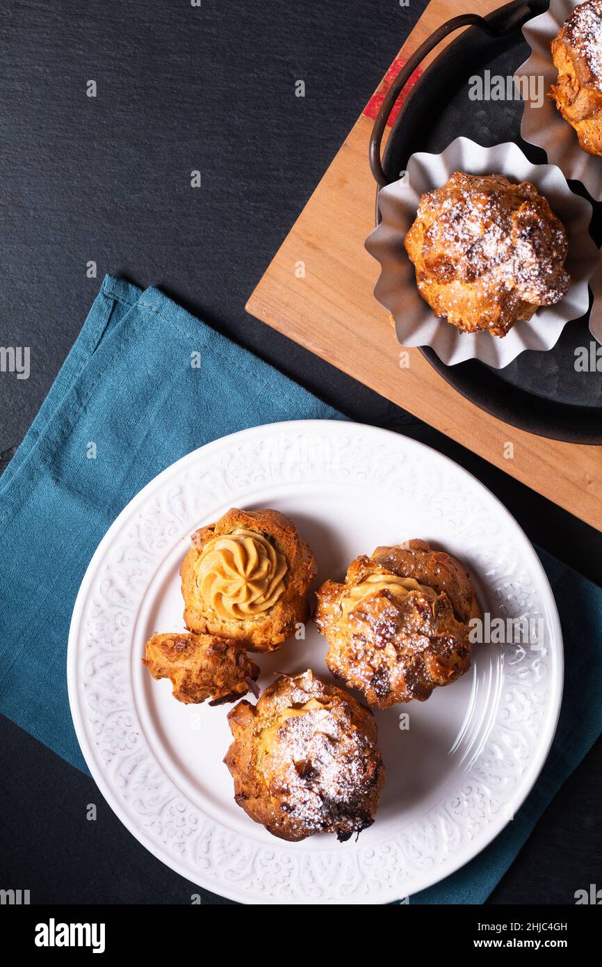 Lebensmittelkonzept hausgemachte Caramel Choux a la Cream oder Choux Cream Puffs auf dunklem Hintergrund mit Kopierfläche Stockfoto