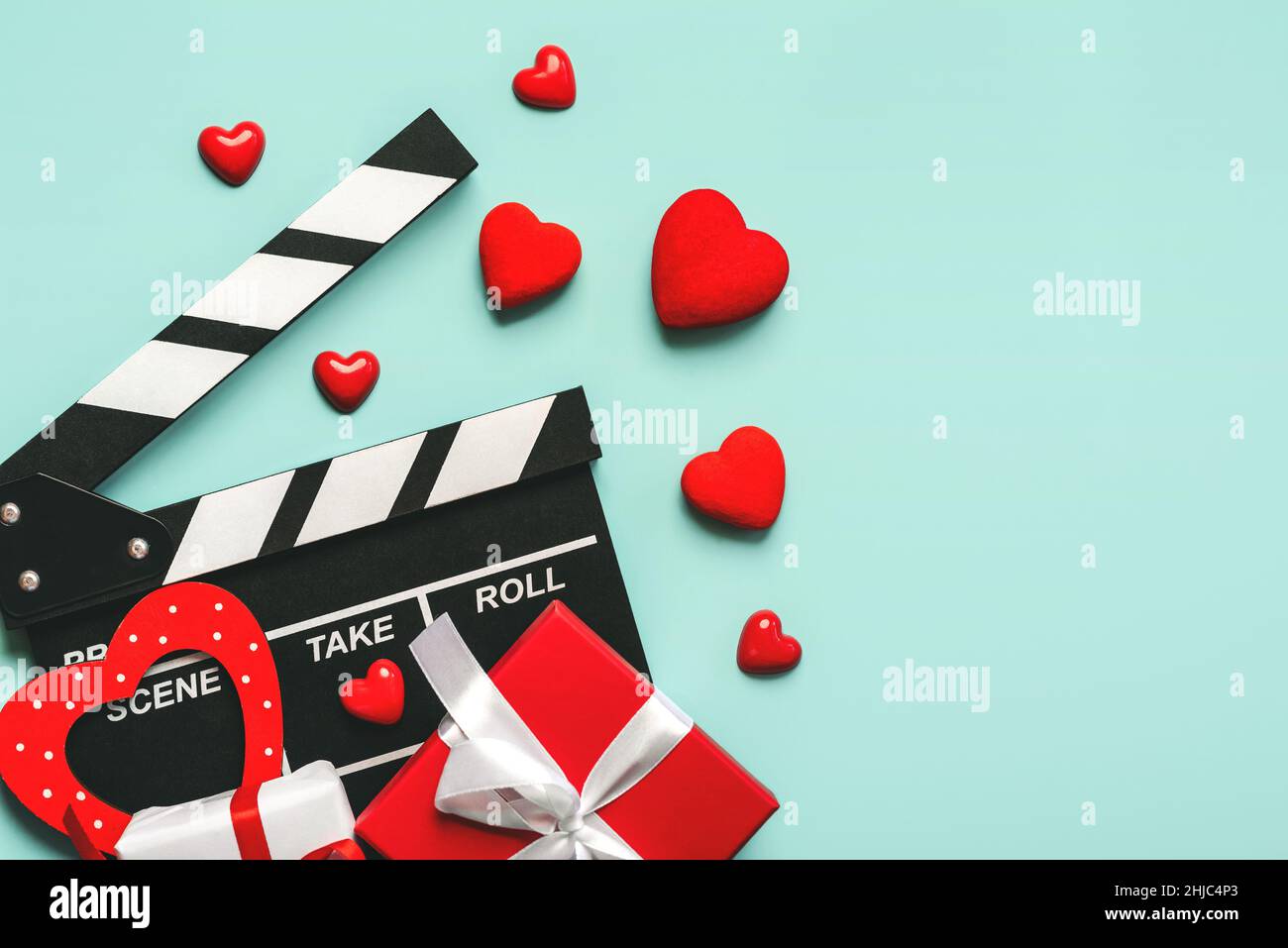 Alles Liebe zum Valentinstag. Klappbrett mit roten Herzen, Valentinstag Geschenkbox und kopieren Raum auf blauem Hintergrund. Romantisches Filmkonzept Stockfoto