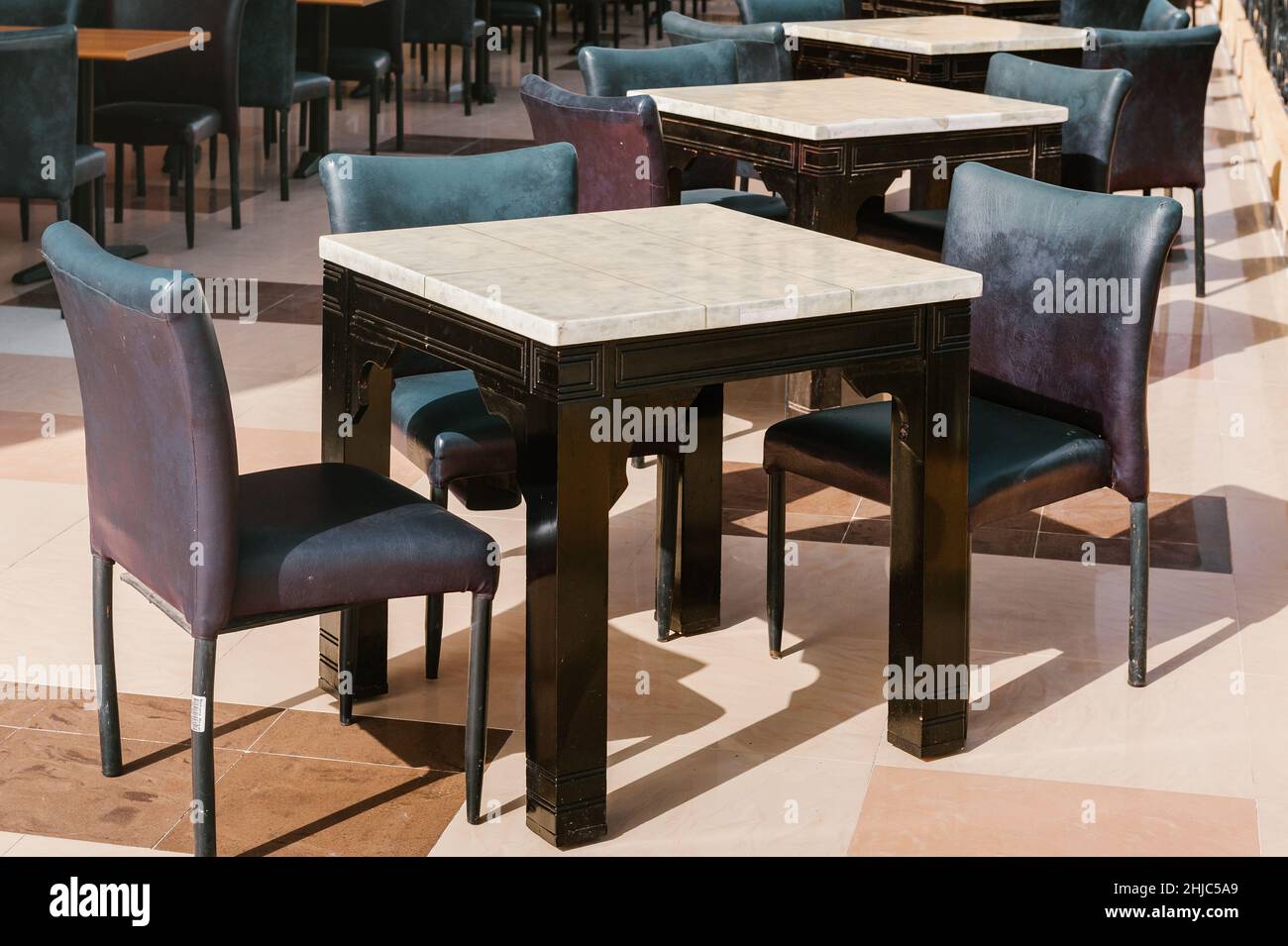 Cafe Restaurant Terrasse Tisch mit Palmen am Meer. Restaurantterrasse. Tropisches Urlaubskonzept. Vintage-Effekt. Tropisches Terrassenparadies Stockfoto
