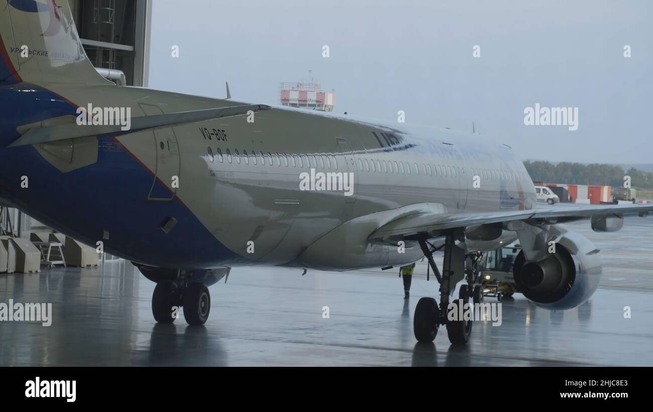 Passagierflugzeuge, Wartung von Motoren und Reparatur des Rumpfes, Verlassen des Hangars des Flughafens. Airbus für die Reparatur im Hangar. Das Flugzeug kommt an Stockfoto
