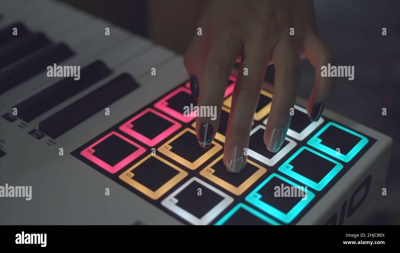Drum Machine im Nachtclub spielt Live Set. Lager. Finger klopfen auf Trommelbeläge an einem digitalen Beatmaker in Nahaufnahme. DJ beginnt mit der Wiedergabe der im eingestellten Musik Stockfoto