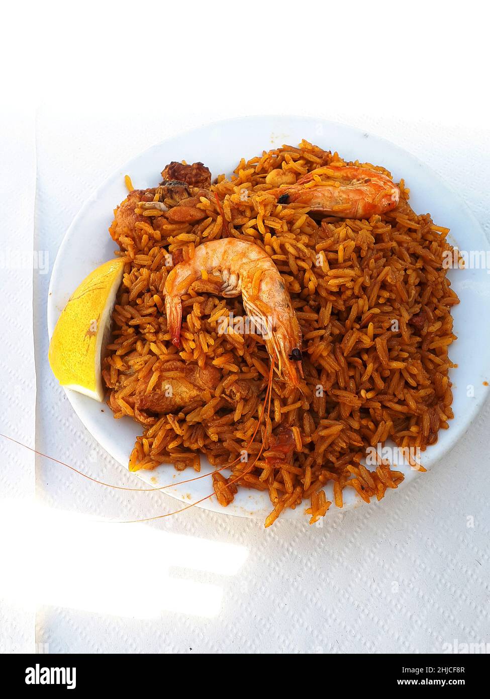 Kochen einer Paella in einer riesigen Eisenpfanne am Strand von Burriana in Nerja an der Costa del Sol in Südspanien. Sie wird aus Reis, Huhn und Garnelen hergestellt Stockfoto