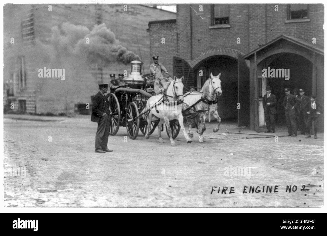 E L Tobias Foto mit dem Titel Fire Engine No 2 - weiß - pferdegezogener Feuerwehrauto mit Rauch, der aus dem Zylinder strömt - 1909 Stockfoto