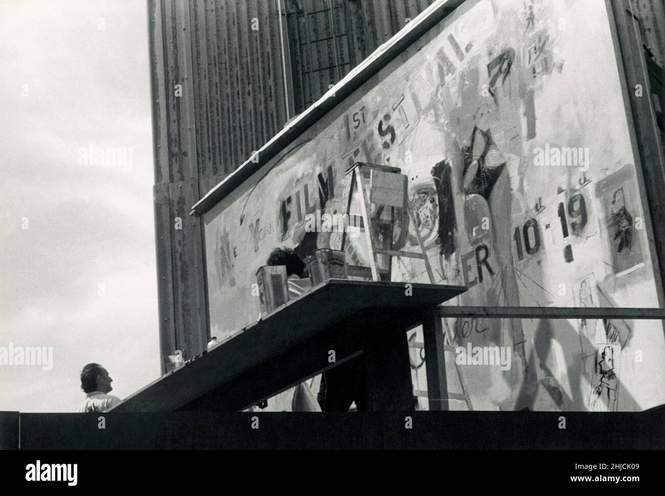 Larry Rowes malt eine Plakatwand für das erste New York Film Festival auf dem Lincoln Square in Manhattan, 1963. Rivers, geborene Yitzrok Loiza Grossberg, begann als Jazz-Saxophonist und war ein Zeitgenosse und Freund von Miles Davis. Als Maler produzierte er Pop-Art, die an das abstrakte grenzte und wurde zu einem der wichtigsten amerikanischen Nachkriegskünstler. Geboren 1923, gestorben 2002. Stockfoto