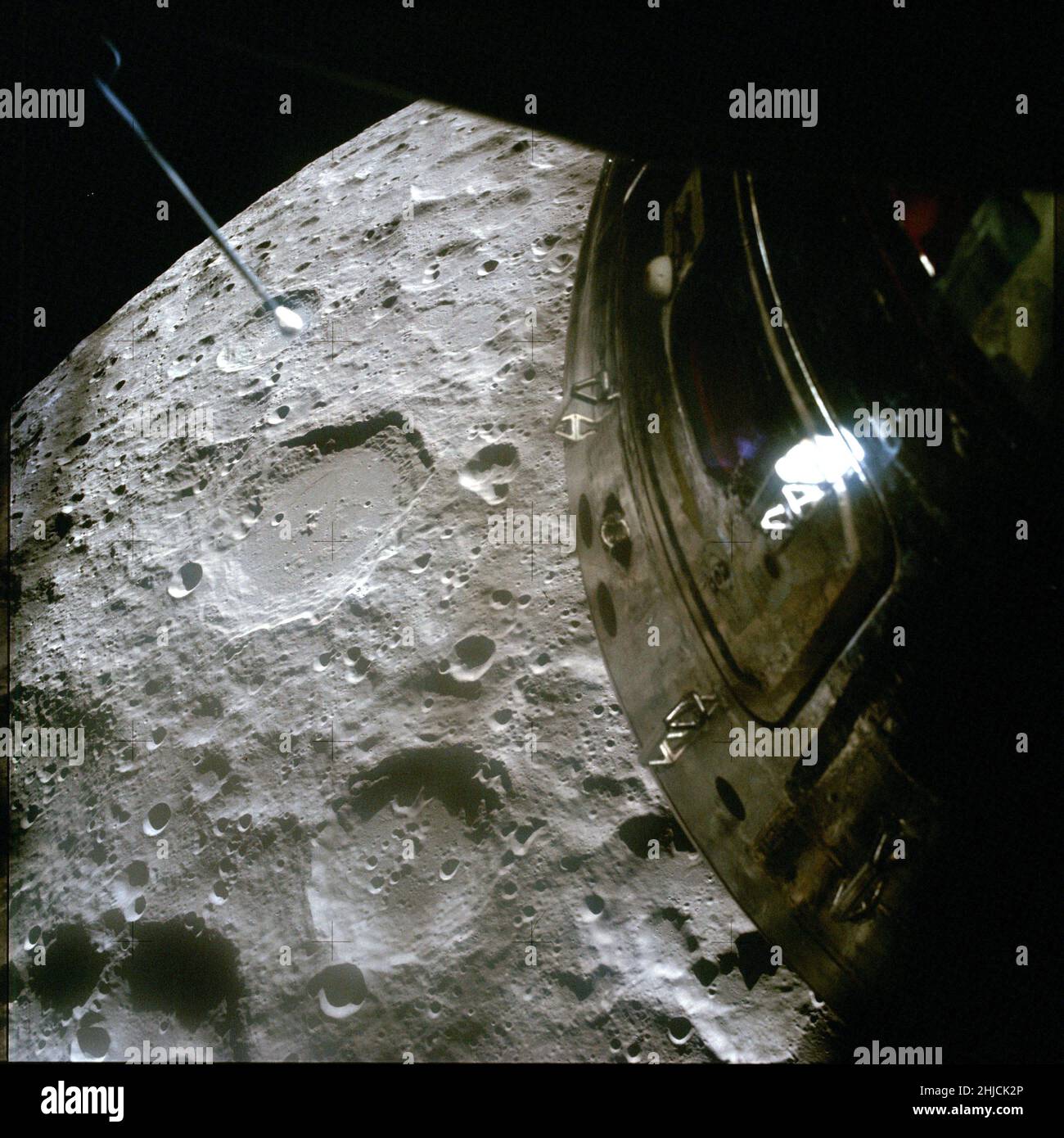 Apollo 13 Ansicht des Mondes. Dieses Foto des Chaplygin-Krater (Mitte links) wurde durch eines der Fenster der Mondlandefähre mit einer Kamera aufgenommen, die für die Oberflächenfotografie vorgesehen war (beachten Sie die plus-förmigen R√©seau-Markierungen). Verschwommene, dunkle, vertikale Streifen sind unscharfe Skalenmarkierungen im LM-Fenster, die zur Beurteilung von Winkeln und Entfernungen verwendet werden. Die Schraffur des Befehlsmoduls ist im Vordergrund hervorstehend. Stockfoto
