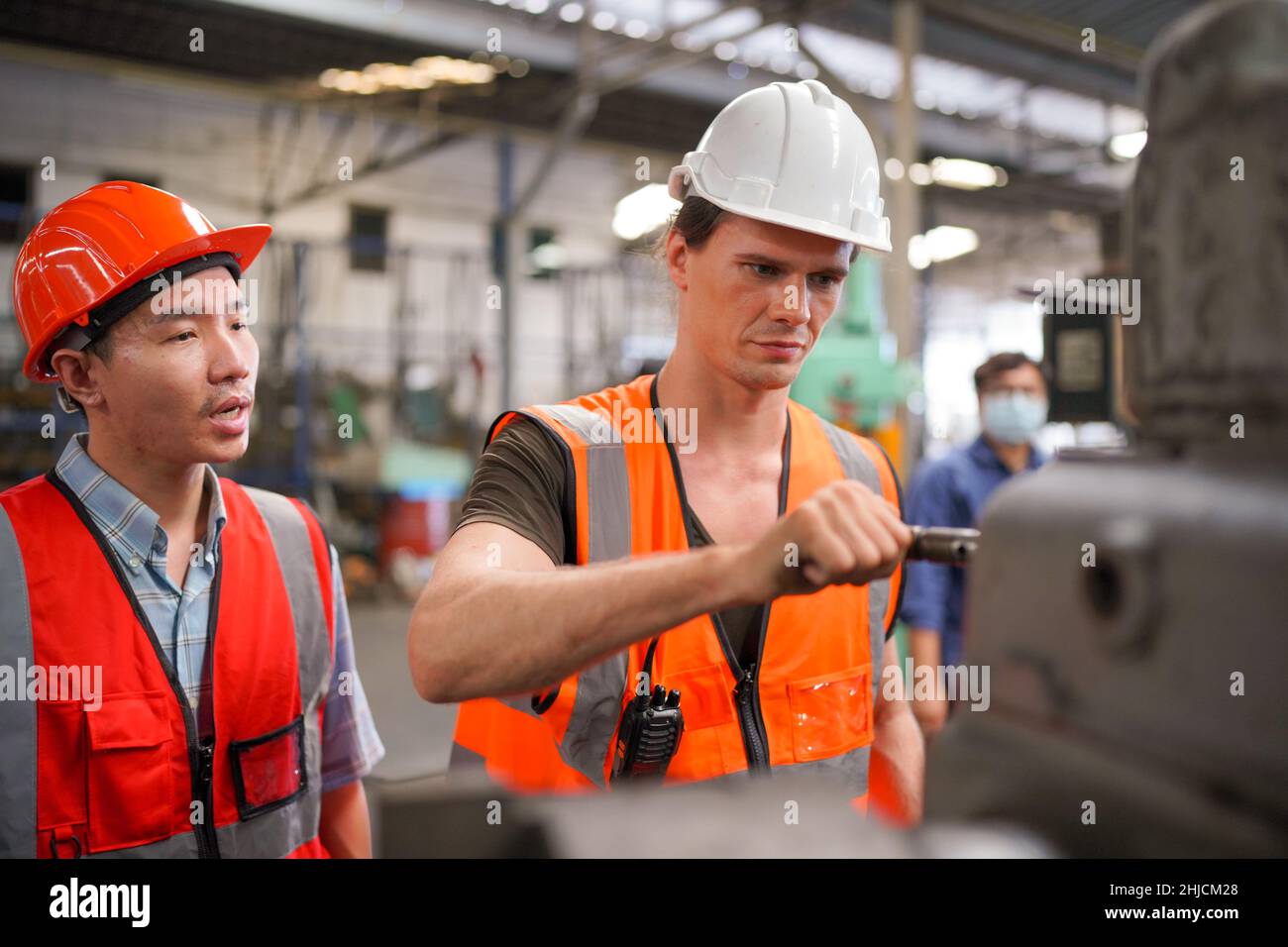 Industrieingenieure in harten Hüten.Arbeiten in der Schwerindustrie Produktionsfabrik. Industriearbeiter in Innenräumen in der Fabrik. Mann, der in einer Industrie arbeitet Stockfoto