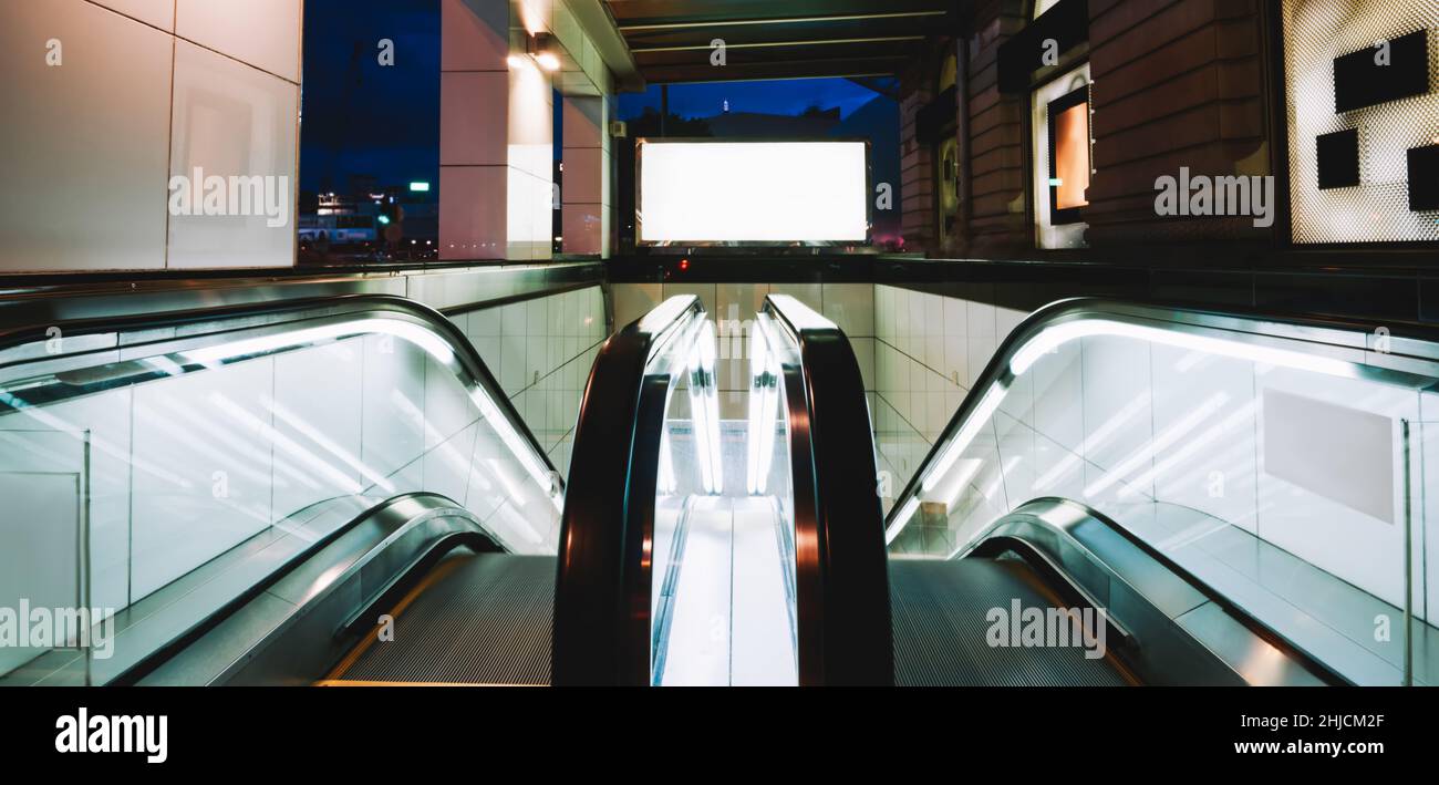 Rolltreppe in einem modernen Gebäude mit leerer Werbetafel Stockfoto