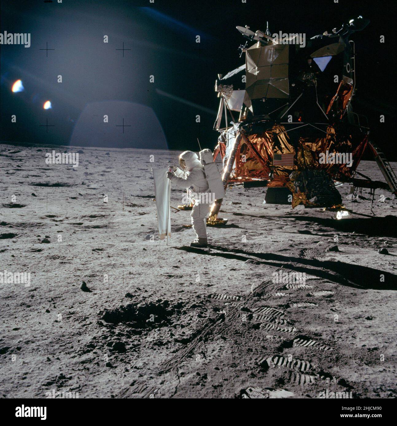 Die Apollo-11-Astronauten Neil Armstrong und Edwin 'Buzz' Aldrin führten am 20. Juli 1969 die erste bemannte Mondlandung durch. Hier setzt Buzz den Solar Wind Collector ein, ein Folienblatt, das er auf die Sonne zeigt. Am Ende der EVA, nachdem er den SWC etwa 1 Stunden und 17 Minuten lang der Sonne ausgesetzt hatte, Buzz wird die Folie zusammenrollen und in einen Beutel packen, um sie auf der Erde zu analysieren. Beachten Sie den beträchtlichen Abstand zwischen der Unterseite der Glocke des Abfahrmotors und der darunter liegenden Oberfläche. Stockfoto