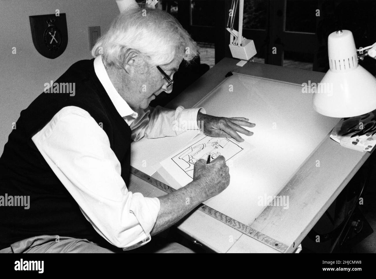 Hank Ketcham, der Schöpfer von Dennis the Menace, an seinem Zeichentisch in seinem Atelier. Stockfoto