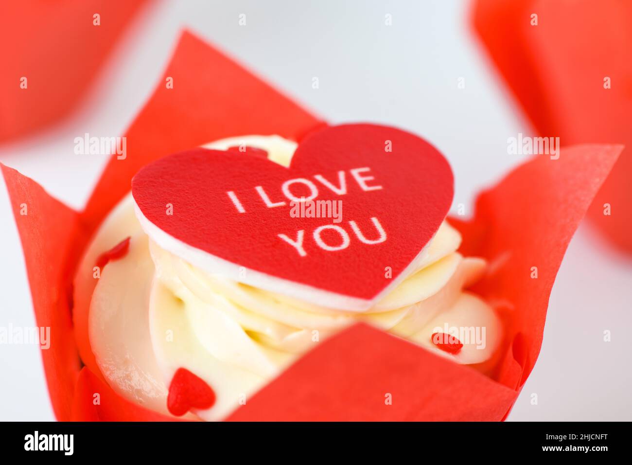 Nahaufnahme eines roten herzförmigen Cupcake mit der Inschrift I love you auf grauem Hintergrund. Valentinstag Stockfoto