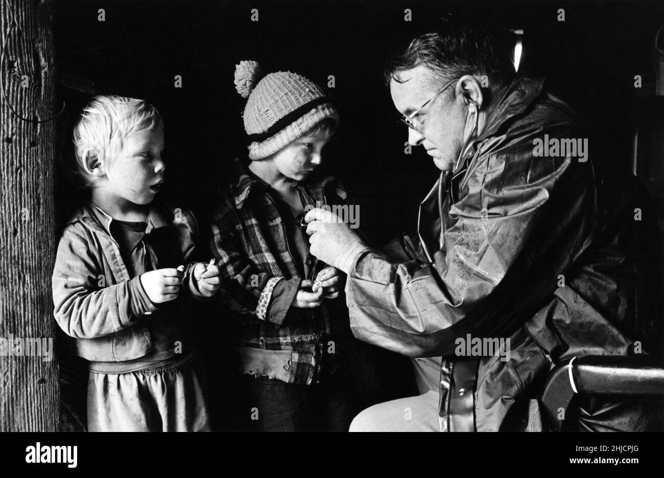 Arzt, der ein Stethoskop verwendet, um den Herzschlag von zwei jungen männlichen Patienten zu hören. Stockfoto