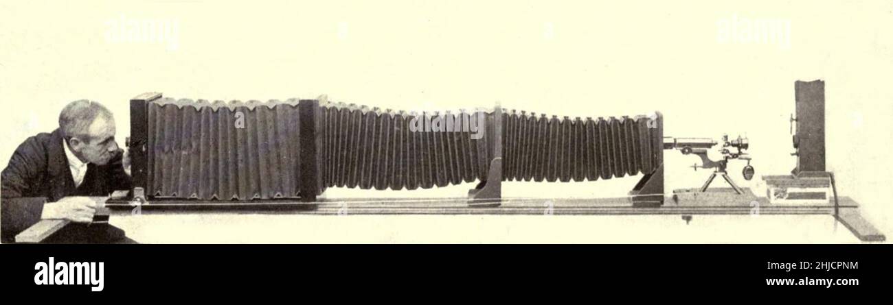 Arthur Smith nimmt Photomikrographen, um 1904. Hier konzentriert er sich auf den Kamerabildschirm, der wiederum auf das Objekt im Mikroskop fokussiert. 1904 stellte die Royal Society in London eine Serie von Smiths Photomikrographen der Öffentlichkeit vor. Sie wurden später 1909 in einem Buch mit dem Titel „Nature Through Microscope & Camera“ veröffentlicht. Sie waren die ersten Beispiele der Photomikroskopie, die viele je gesehen haben. Stockfoto