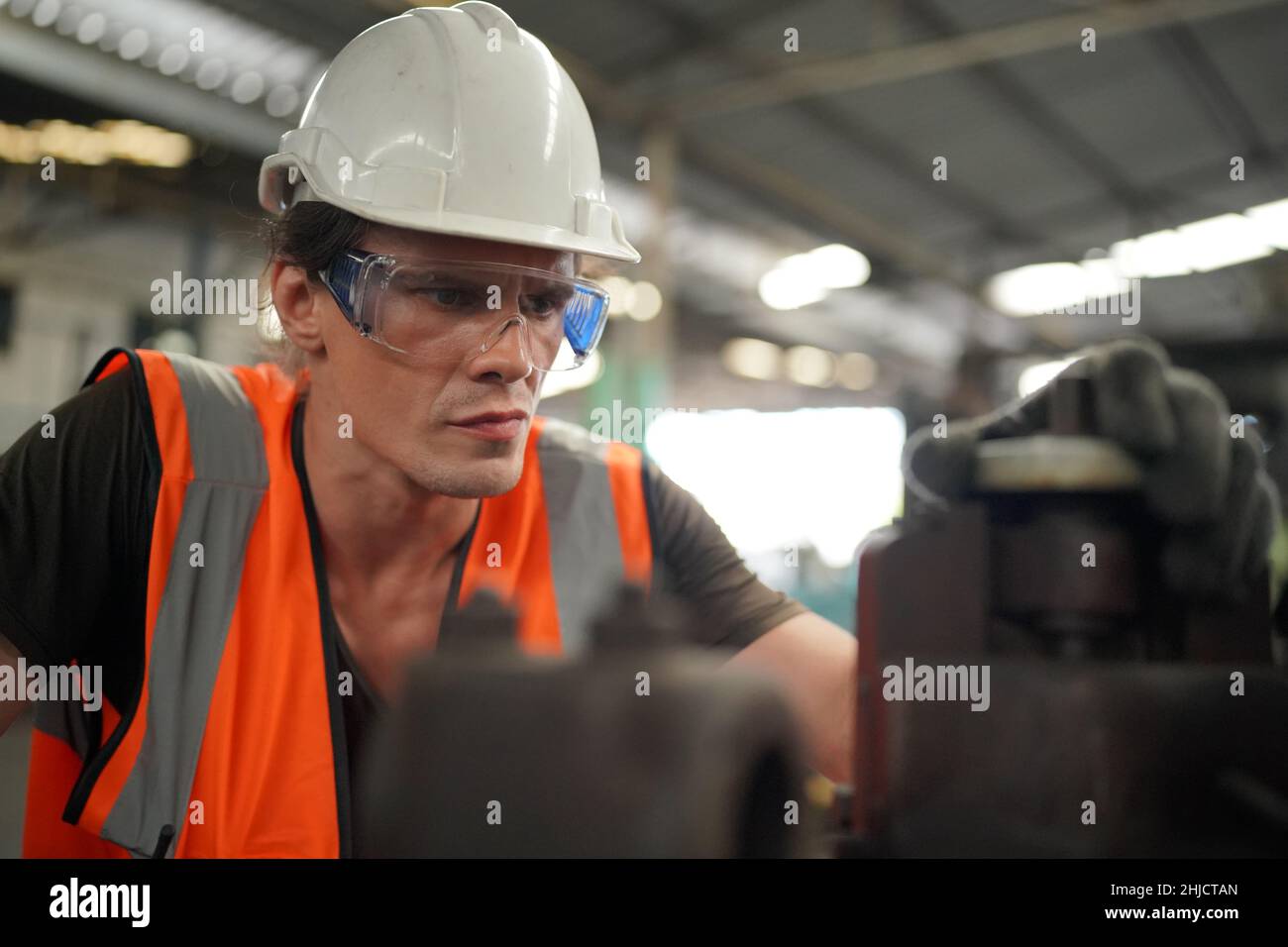 Industrieingenieure in harten Hüten.Arbeiten in der Schwerindustrie Produktionsfabrik. Industriearbeiter in Innenräumen in der Fabrik. Mann, der in einer Industrie arbeitet Stockfoto