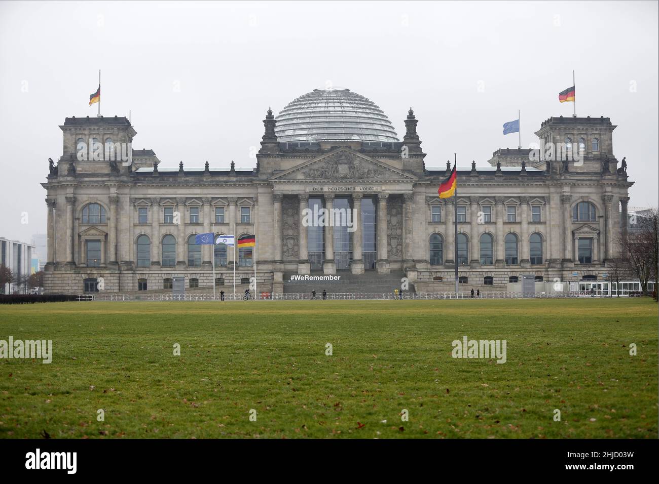 Berlin, Deutschland. 27th Januar 2022. Der Deutsche Bundestag beteiligt sich in diesem Jahr an der Kampagne „#WeRemember“ anlässlich des Internationalen Holocaust-Gedenktages am Donnerstag, 27. Januar 2022. Das Foto zeigt das Reichstagsgebäude mit Flaggen am Halbmast und weißen Buchstaben WeRemember. (Foto: Simone Kuhlmey/Pacific Press/Sipa USA) Quelle: SIPA USA/Alamy Live News Stockfoto