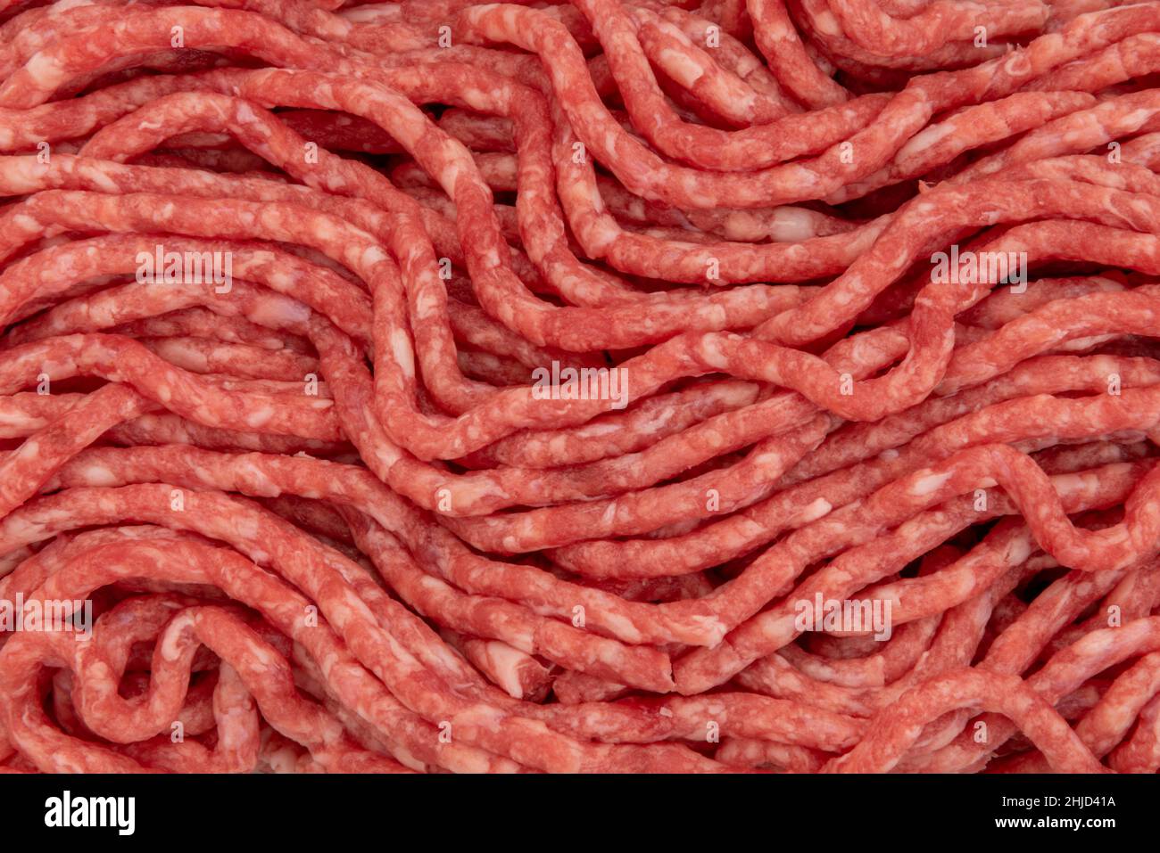 Hackfleisch mit Fleischtextur im Hintergrund, rohes Hackfleisch in Nahaufnahme in der Draufsicht Stockfoto