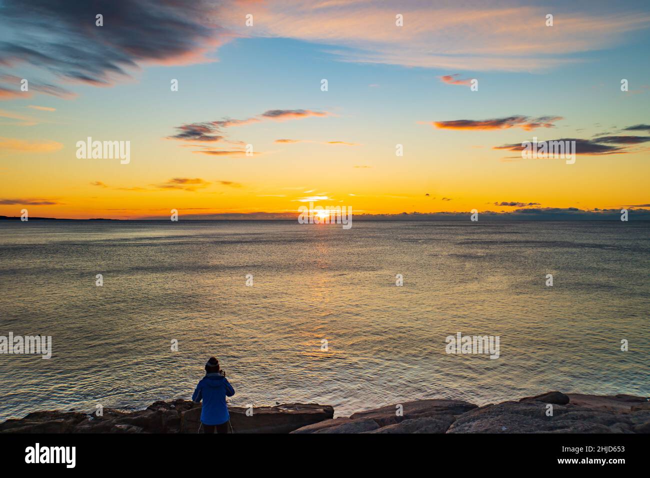 Fotograf, der den Sonnenaufgang am Horizont des Atlantiks im Acadia National Park, Maine, USA, einfängt Stockfoto
