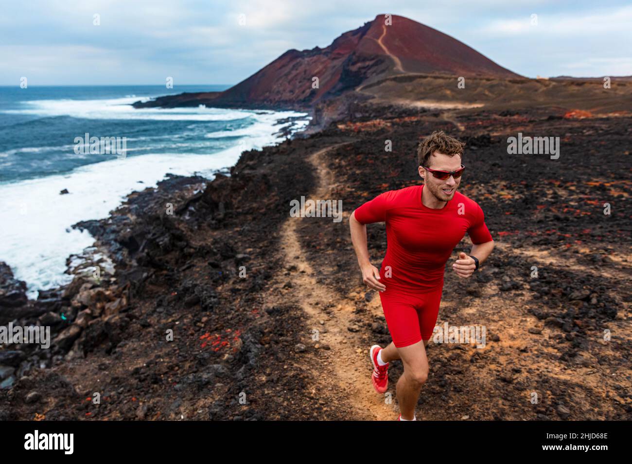 Läufer Mann Sport Athlet Ultra Laufen auf Ausdauer Trail Rennen Wettkampftraining auf Vulkanklippe tragen Kompressionskleidung, Sonnenbrille Stockfoto