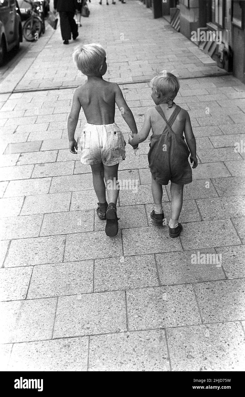 Sommer im Jahr 1950s. Zwei Kinder gehen auf dem Bürgersteig entlang und halten sich gegenseitig die Hände. Schweden 1954. Kristoffersson BC42-12 Stockfoto