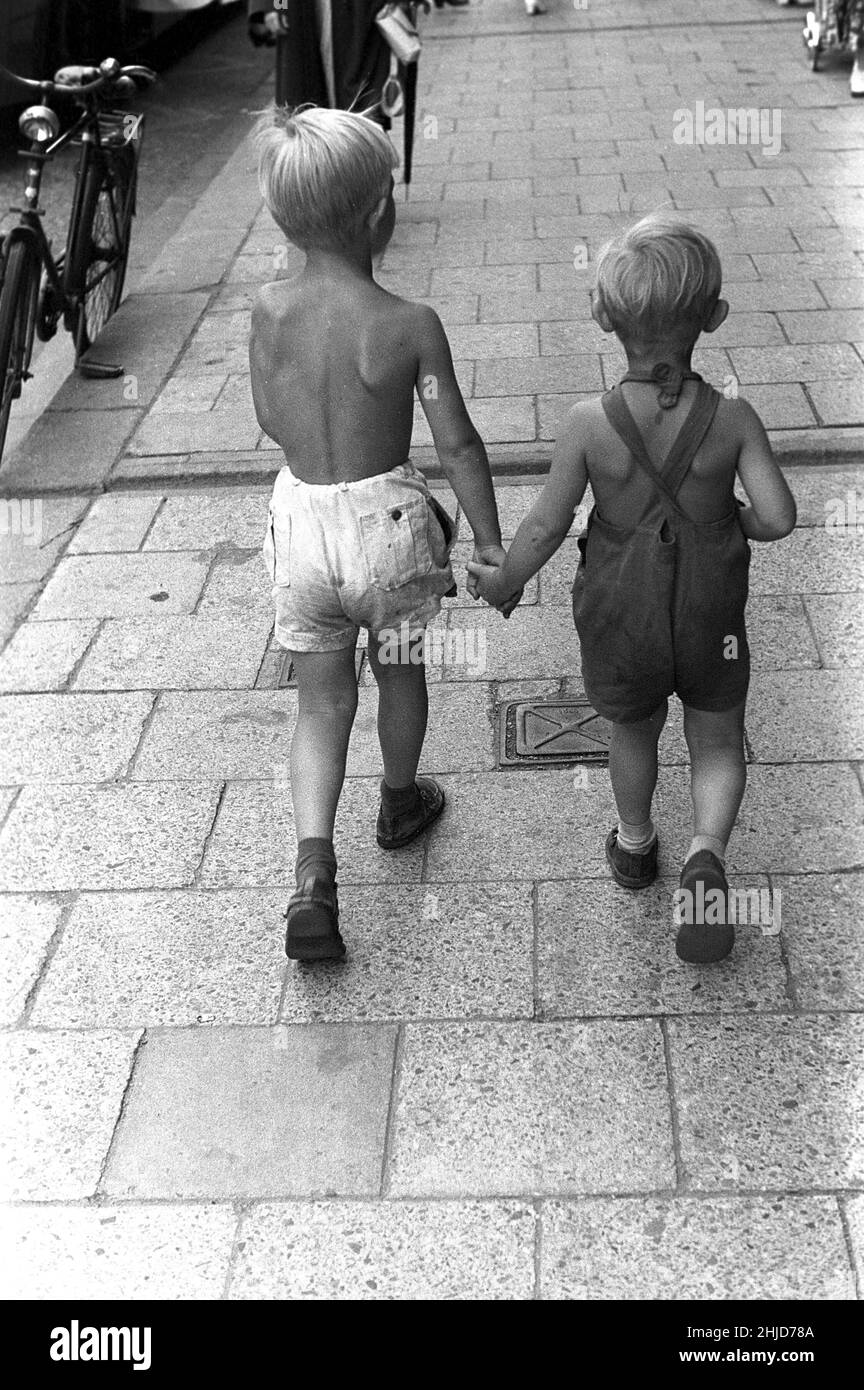 Sommer im Jahr 1950s. Zwei Kinder gehen auf dem Bürgersteig entlang und halten sich gegenseitig die Hände. Schweden 1954. Kristoffersson BC42-12 Stockfoto