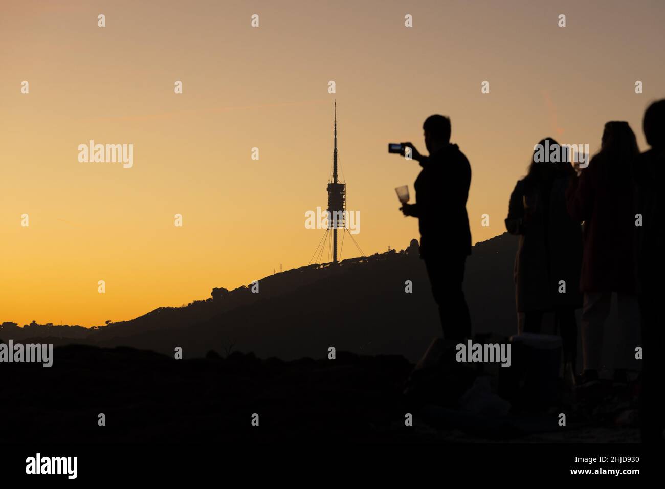 Eine Gruppe von Menschen, die Fotos von dem wunderschönen Sonnenuntergang machen Stockfoto