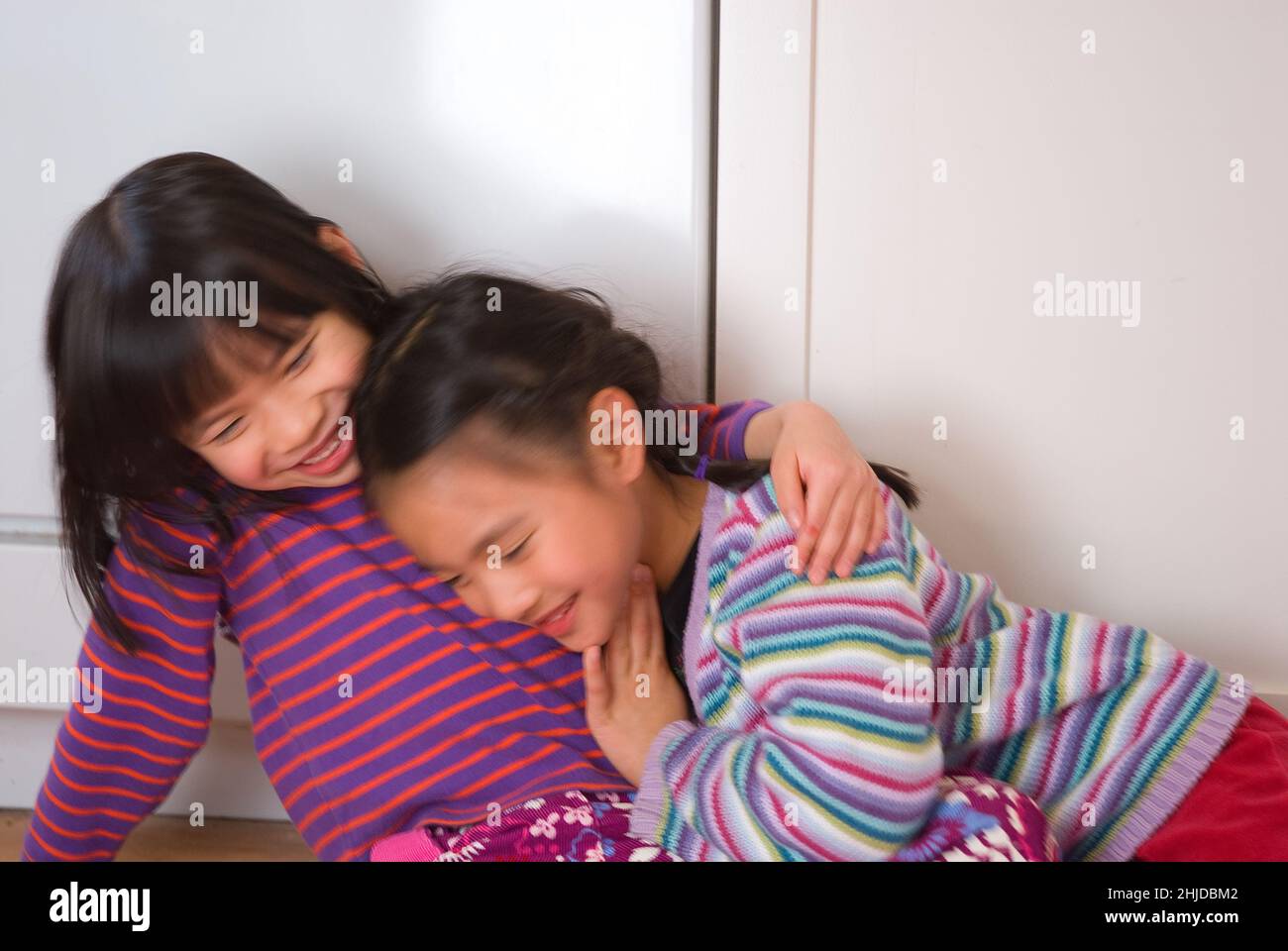 Zwei fünfjährige Mädchen umarmen sich, Freunde seit der Kindheit Stockfoto