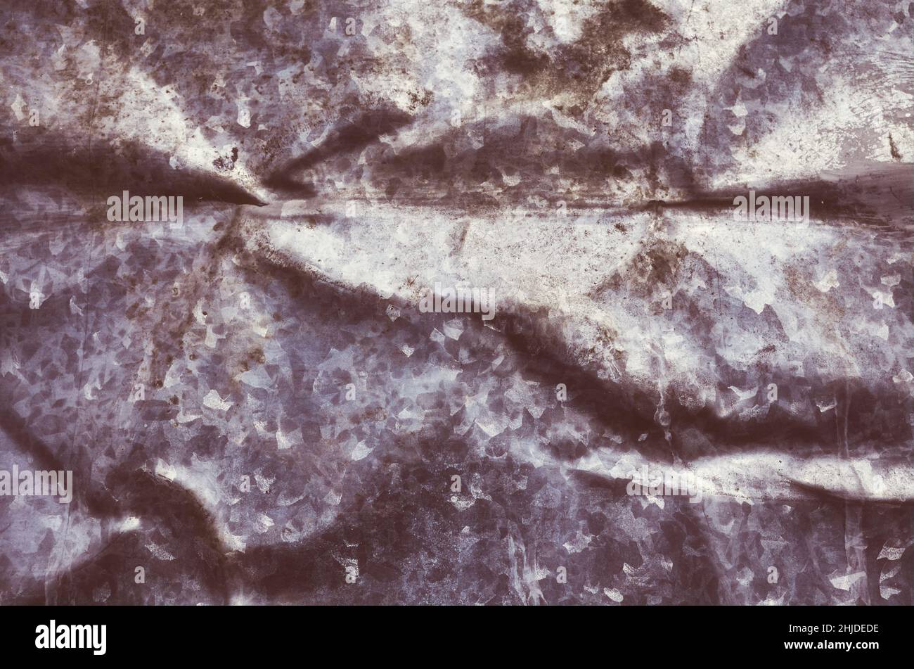 Retro-Farbbild eines alten, geknitterten Metallblechs, dunkler abstrakter Grunge-Hintergrund oder Textur. Stockfoto