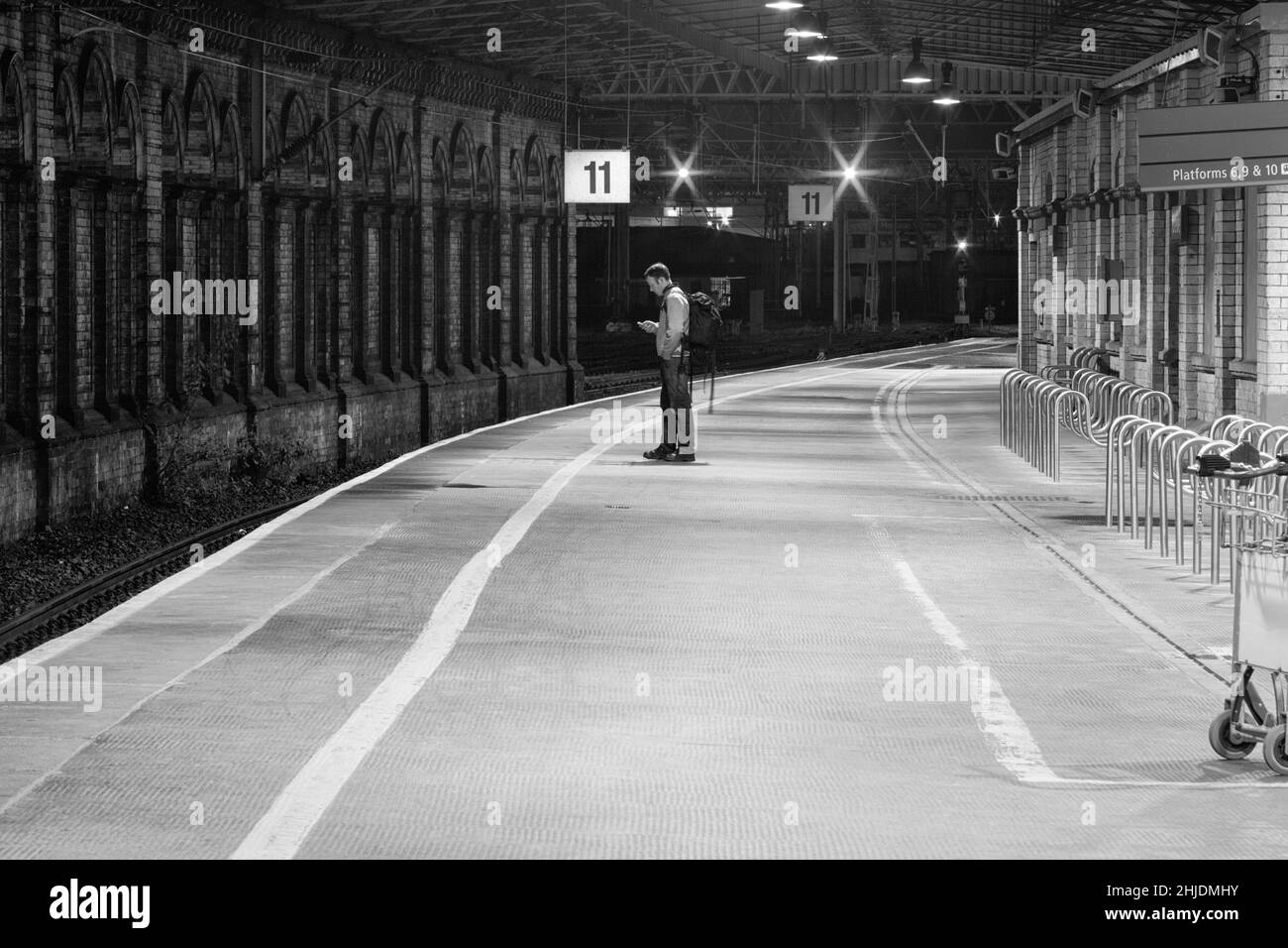 Londe-Passagier wartet am Bahnsteig 11 des Bahnhofs Crewe mit roten Signalen Stockfoto