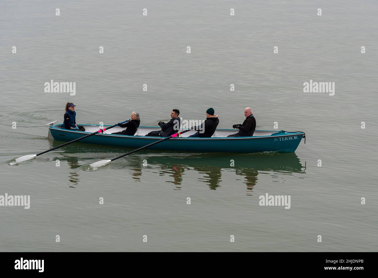 Vier Ruder Rudern Rudern Club Celtic Longboat namens Terror, gerudert auf der Themse Mündung vorbei Southend on Sea an einem nebligen, ruhigen Morgen Stockfoto
