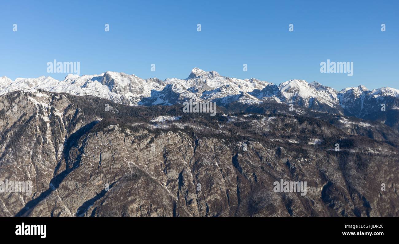Berggipfel mit Schnee bedeckt über grauen Felsen Stockfoto