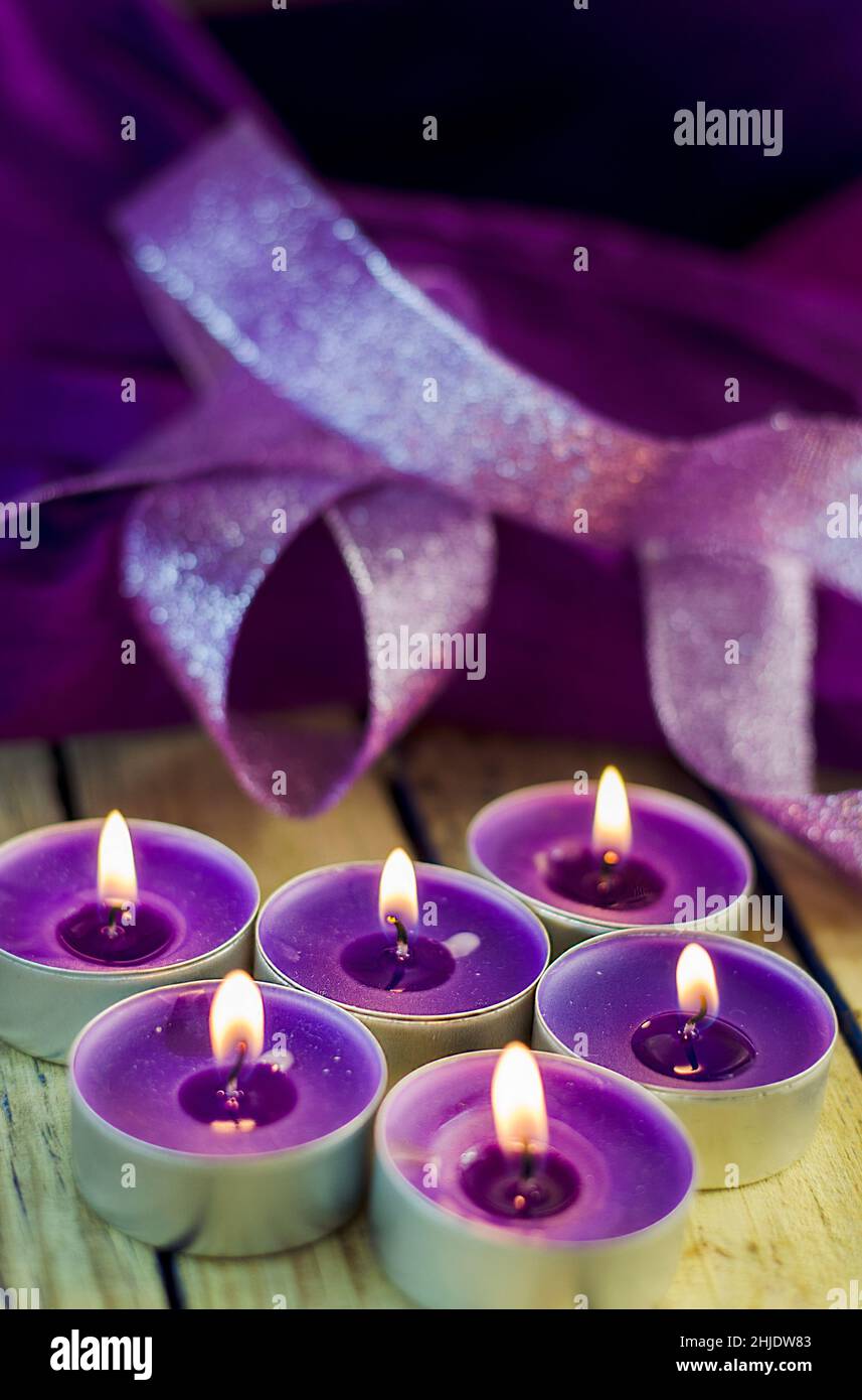 Aromatisch brennende Duftkerzen in violetten Tönen Stockfoto