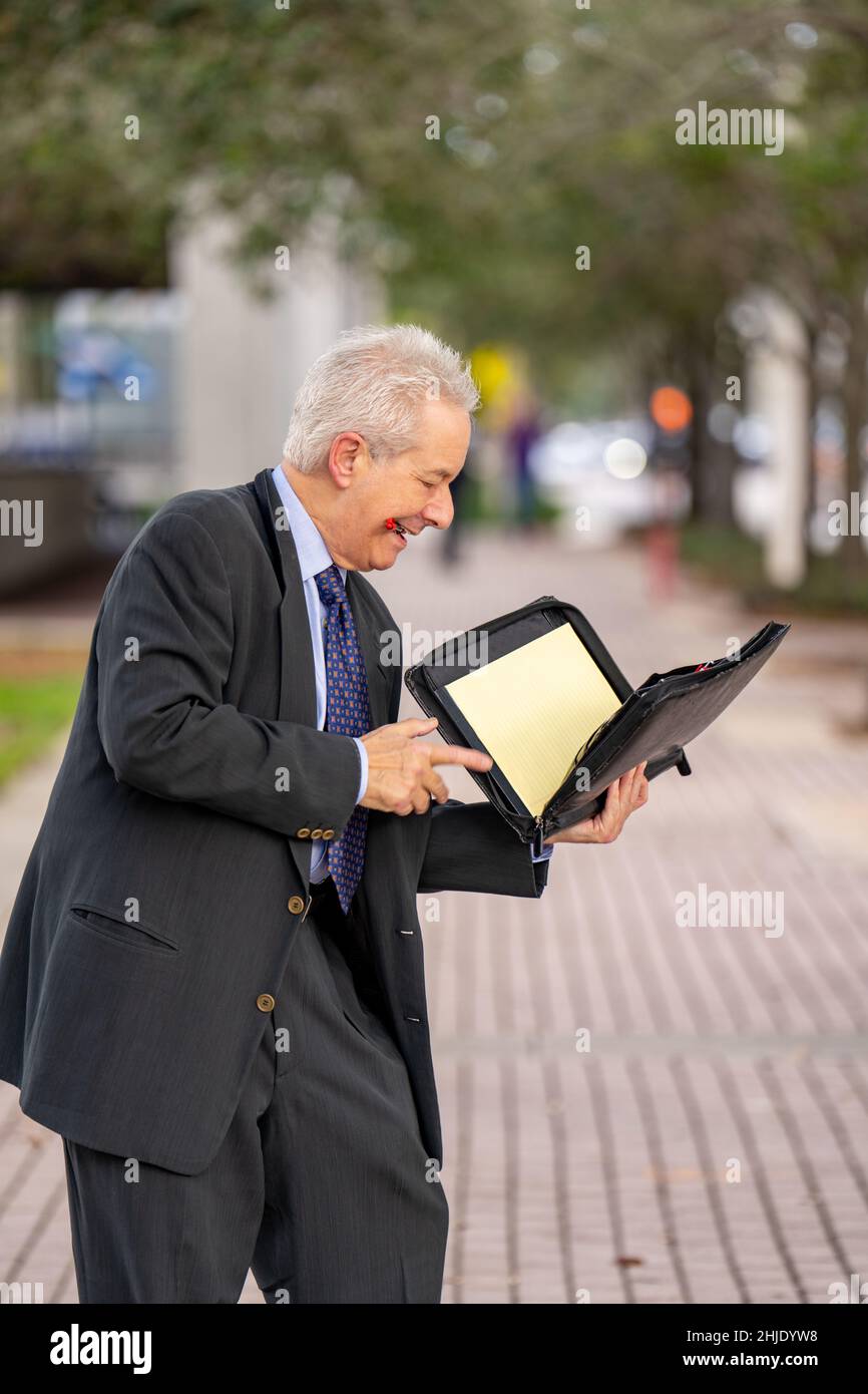 Geschäftsmann fummelt durch sein Notizbuch Stockfoto