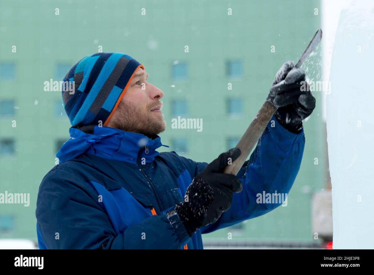 Der Bildhauer schneidet ein Eis Abbildung aus Eis mit einem Meißel für Weihnachten Stockfoto