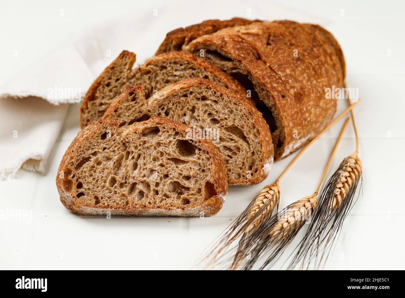 Nahaufnahme Textur Scheiben Sauerteig Brot auf weißem Tisch, gesunde Backwaren. Handwerkliche Brotkrebse-Textur. Stockfoto