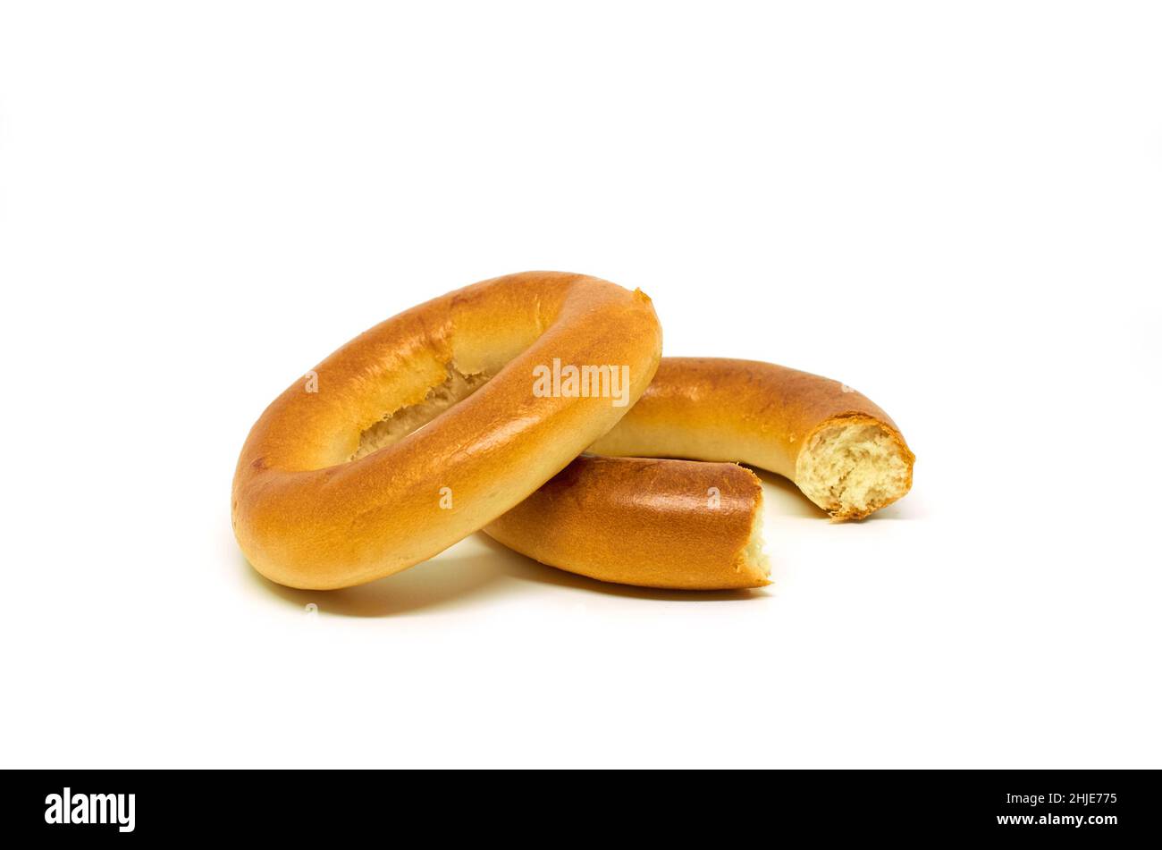 Ganze und gebissene Bagels auf weißem Hintergrund Stockfoto