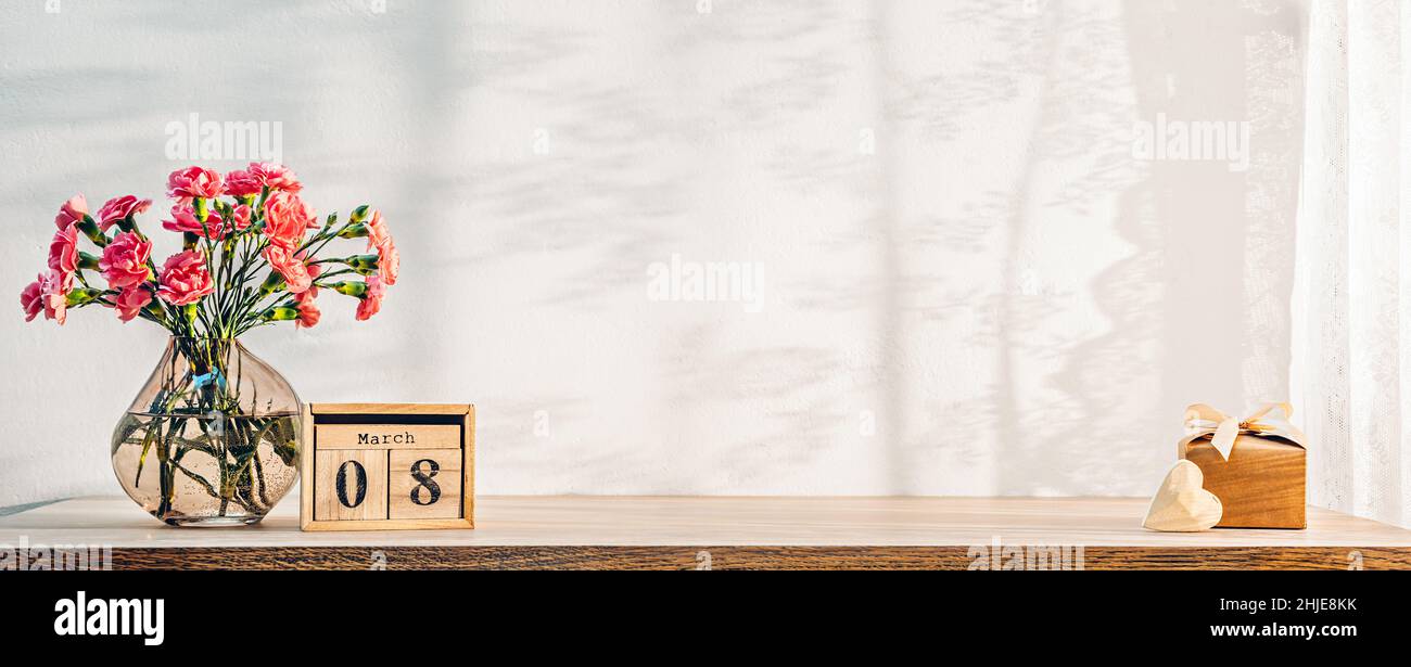 Blumen, Kalender, Holzherz und Geschenk auf dem Tisch als Hintergrund für den Frauentag Stockfoto