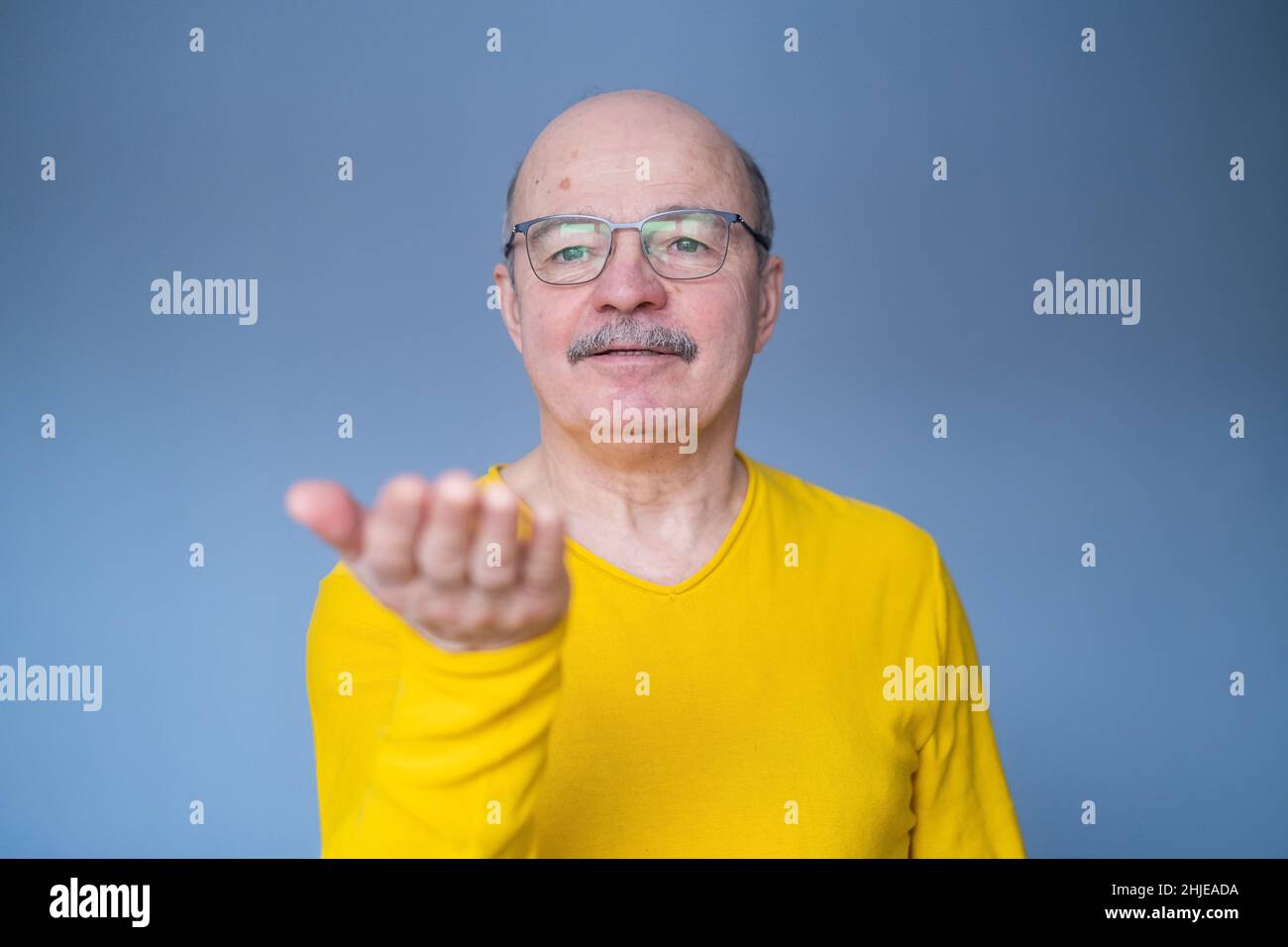 Älterer Mann, der etwas auf seiner Handfläche zeigt. Ort für Ihr Produkt. Stockfoto