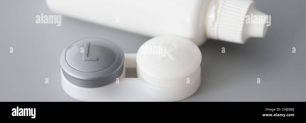 Aufbewahrungsbehälter für weiche Kontaktlinsen und Lösungsflasche auf dem Tisch Stockfoto