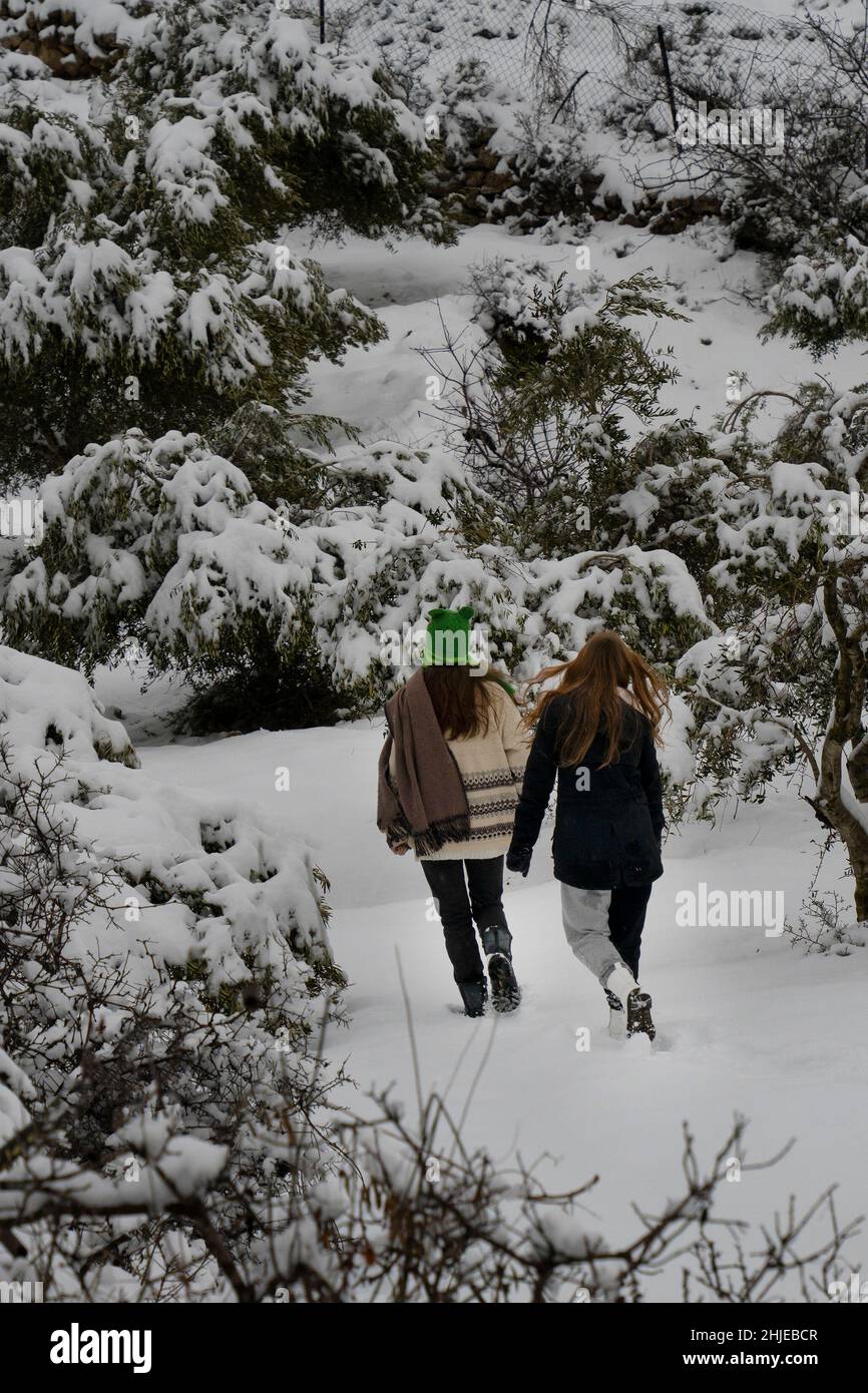 Zwei junge Frauen machen einen Spaziergang im Schnee in den Judäa-Bergen in der Nähe von Jerusalem, Israel. Stockfoto