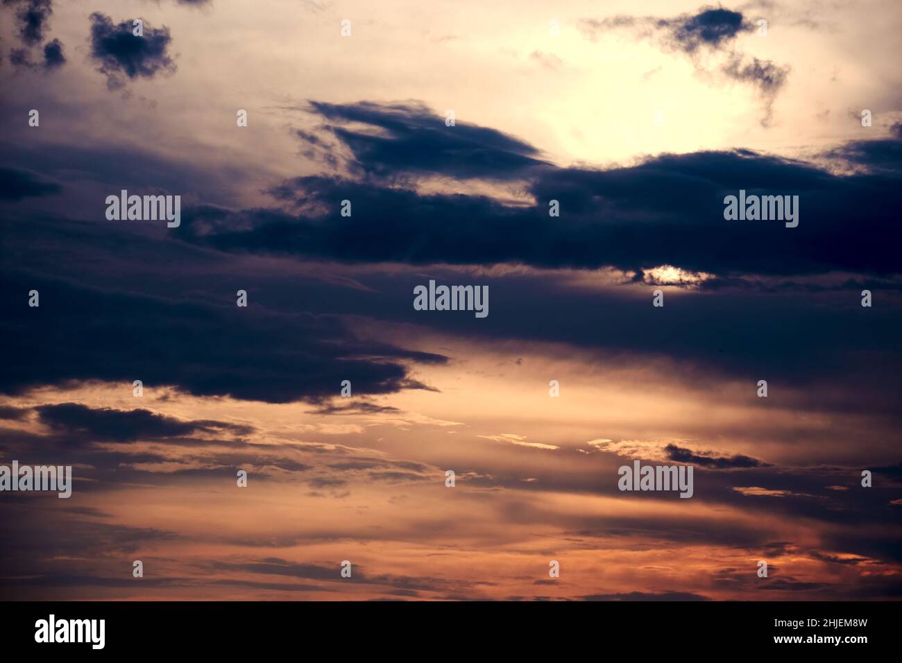 Dramatischer Abendhimmel mit vielen dunklen Wolken und Sonnenstrahlen. Abstrakte Natur Hintergründe Stockfoto