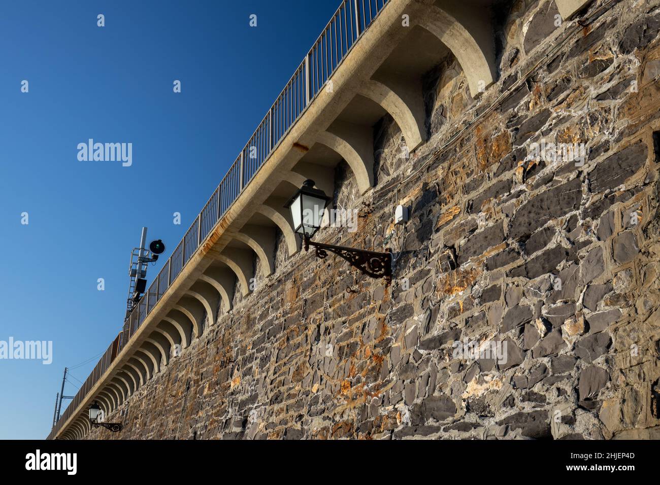 Italien, Genua - der Damm der Eisenbahn, die die Stadt Nervi mit dem charakteristischen Laternenpfosten durchquert, der die Promenade unten beleuchtet Stockfoto