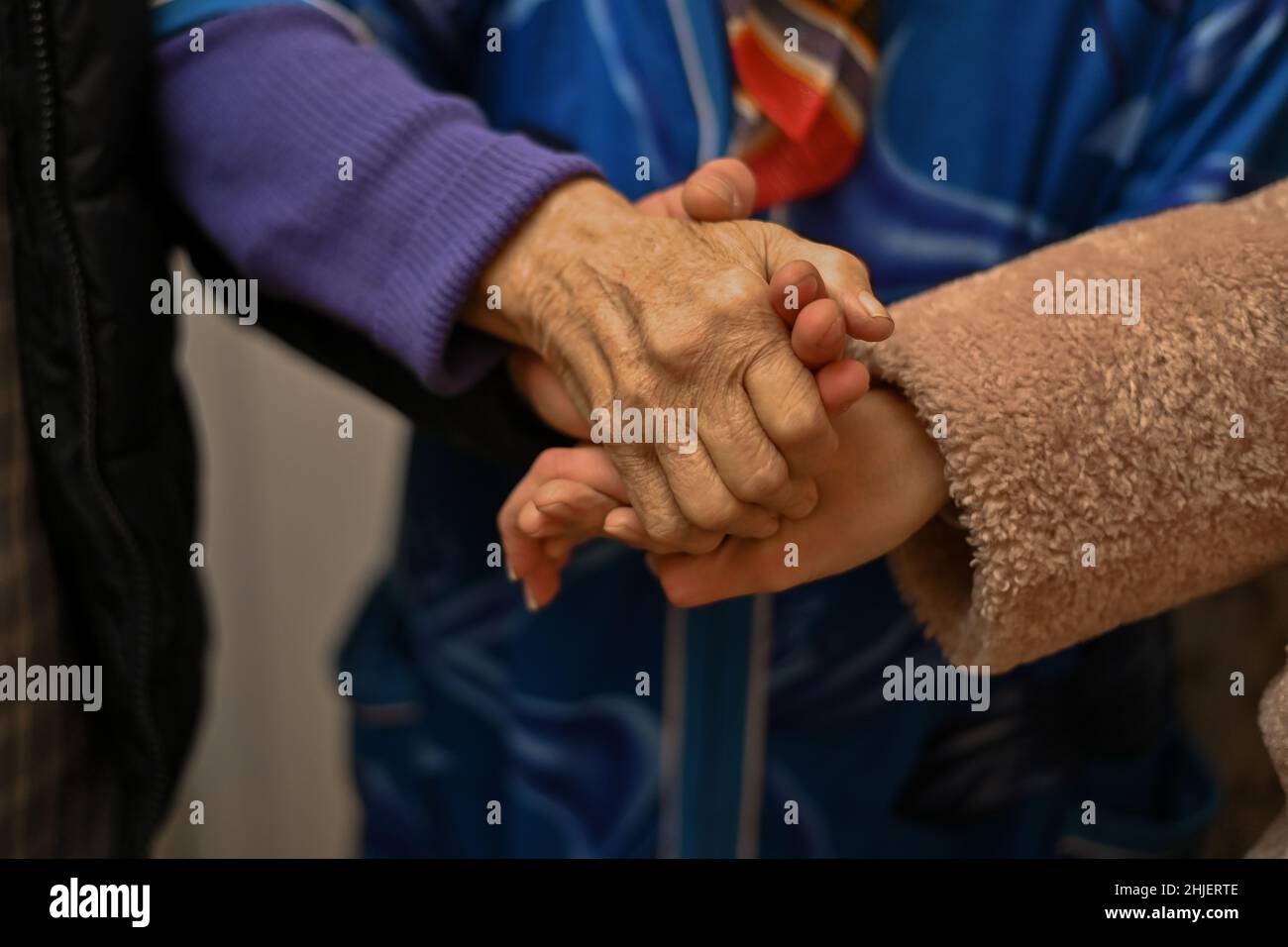 Großmütter halten die Hände junger Männer und Frauen Stockfoto