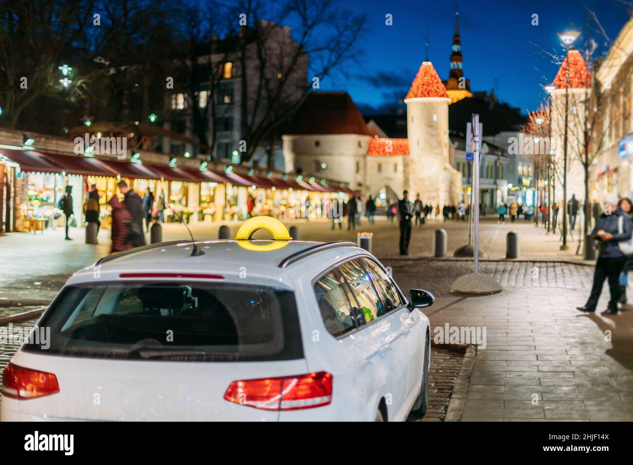 Tallinn, Estland. Taxi Auto Parken in der Nähe von Viru Gates Eingang zum alten Teil der Stadt der estnischen Hauptstadt. Wahrzeichen Viru Tor bei der Straßenbeleuchtung am Abend Stockfoto