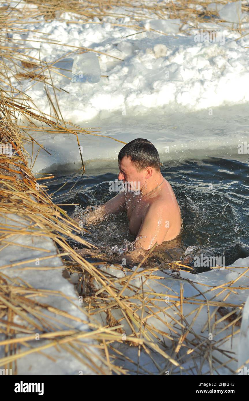 Poltawa, Ukraine. Januar 19. 2017. Ein Mensch steigt im Winter, dem Fest der Epiphany, ins Wasser herab. Orthodoxe Wintertraditionen, Schwimmen in einem Loch Stockfoto